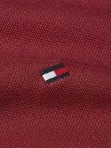 Chomba de manga larga Tommy Hilfiger confeccionada en piqué de algodón elástico, color bordó. Presenta cuello tipo polo con cierre frontal de cremallera, puños acanalados y logo de la marca bordado en el pecho.