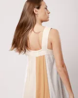 Vestido largo de lino color blanco, gris y amarillo, con breteles anchos, escote recto, elástico en la espalda y tajos laterales.