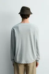 Camiseta de manga larga con ajuste relaxed fit y cuello redondo amplio, confeccionada en tejido de mezcla de algodón y lino con patrón de rayas horizontales en color verde y blanco.