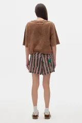 Remera color crudo de algodón lavado, corte cropped y mangas cortas. Presenta un pequeño bordado con las iniciales "PS" en el pecho.