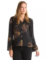 Camisa de crepe con estampado floral en tonos verdes y marrones, cuello con solapa, cierre frontal con botones y detalle de mostacillas bordadas en los hombros. Presenta mangas largas con terminación amplia.