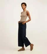 Blusa sin mangas color beige confeccionada en tejido de punto con textura acanalada y cuello redondo.