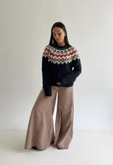 Sweater de cuello redondo con diseño de jacquard estilo nórdico en la parte superior, combinando tonos azul marino, blanco y rojo. Presenta mangas largas y puños acanalados.