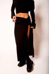 Pollera midi negra de corte recto con tajo lateral alto y cintura alta.