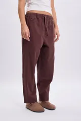 Pantalón casual marrón de corte holgado y relajado, con cintura elástica y cordón ajustable.