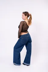 Pantalón de jean estilo wide leg en color azul oscuro, con talle medio y ruedo con doblez ancho.