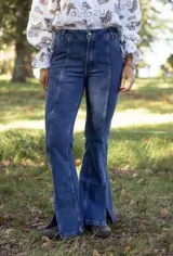 Jean de tiro alto con corte acampanado y aberturas laterales en el ruedo. Presenta costuras verticales decorativas en el frente que estilizan la silueta.