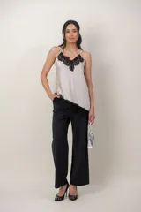Musculosa de satén color beige con aplicación de encaje negro en el escote y breteles finos ajustables.