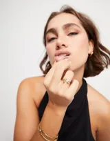 Anillo abierto bañado en oro amarillo 18k con un topacio blanco engarzado en un extremo y una barra vertical en el otro.