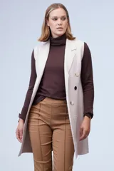 Chaleco largo tejido color blanco de la marca Sioni, con cuello solapa, doble botonadura dorada en el frente y bolsillos aplicados.