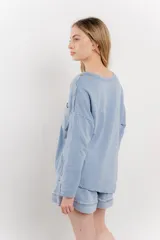 Remera manga larga color rosa con bolsillo en el pecho y corte irregular en el ruedo.