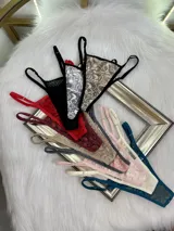 Pack de tres microtangas de encaje con diseño floral, cuentan con tiras laterales regulables y bordes con terminación en cinta elástica. El set incluye una prenda negra, una blanca con estampado floral negro y una beige con estampado floral negro.