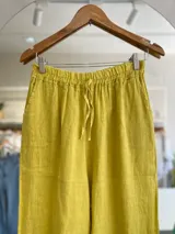 Pantalón palazzo amarillo de lino con cintura elástica y cordón ajustable.