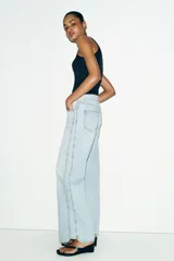 Jeans de tiro bajo con cinco bolsillos, pernera recta y detalle de costuras marcadas en la parte delantera. Cierre frontal con cremallera y botón.