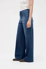 Jean de corte wide leg con tiro medio, confeccionado en denim azul clásico. Presenta un diseño holgado desde la cadera hasta el bajo, con pierna ancha y relajada.