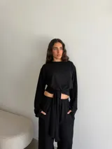 Buzo negro de manga larga con cuello redondo y tiras incorporadas en el frente para anudar a la cintura.