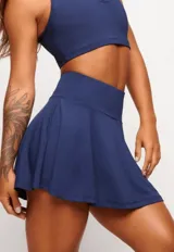 Pollera short deportiva color verde esmeralda, con short interno con bolsillos laterales.