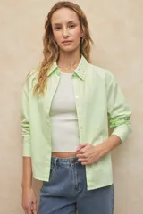 Camisa blanca de algodón con cuello clásico y mangas largas. Detalle de tachas plateadas en el cuello.