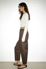 Pantalón de tiro medio con diseño barrel, pernera holgada que se estrecha hacia el tobillo, bolsillos delanteros y bolsillos de plastrón en la espalda. Confeccionado en tejido con textura de espiga, cuenta con cierre frontal de cremallera, botón interior y gancho.