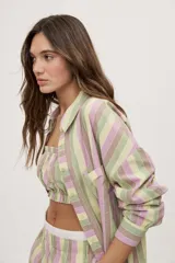 Camisa oversize de manga larga con estampado de rayas verticales en tonos rosado, celeste y verde menta. Cuenta con cuello camisero, cierre frontal con botones y un bolsillo aplicado en el pecho.