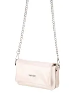 Bandolera color nácar con acabado suave, diseño compacto y solapa frontal con logo metálico. Incluye una cadena metálica plateada como correa.