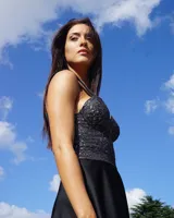 Vestido corto negro con bustier de lúrex plateado y tirantes anchos. Falda acampanada de satén triple con spandex.