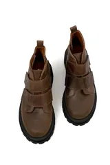 Botas marrones de cuero con suela track negra y ajuste con dos tiras de velcro.