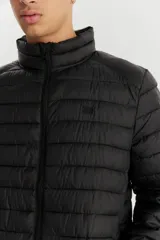 Campera puffer negra con cierre frontal y cuello alto.