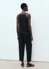 Pantalón largo negro de lino con diseño recto, cintura elástica con cordón ajustable y bolsillos laterales.