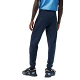 Pantalón de jogging azul marino de corte slim fit con cintura elástica y cordón ajustable. Estampado con el logo de Lacoste en blanco en la pierna izquierda.