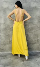 Vestido largo amarillo con espalda descubierta y breteles finos.