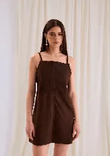 Vestido corto de cuero color marrón chocolate, de silueta recta y escote cuadrado, con tirantes finos y costuras decorativas a la vista.