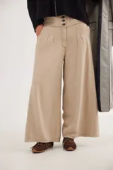 Pantalón de jean con diseño de tiro medio-bajo y piernas anchas. Presenta una pretina ancha con cierre de tres botones metálicos frontales, pinzas decorativas en la cintura y bolsillos delanteros funcionales.