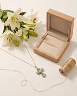 Collar de cadena fina con baño de oro y dije de cruz con incrustaciones de piedra abulón y borde decorado con circonias.