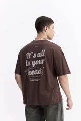 Remera de manga corta color marrón, con escote redondo y estampado en la espalda que dice "It's all in your head" y "Your anxiety is lying to you".