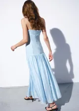 Vestido midi celeste de lino con escote recto, tirantes finos, cuerpo fruncido y falda evasé con volados.