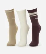 Kit de tres pares de medias largas Puma de algodón con textura acanalada, incluye un par en color tostado, un par en blanco y un par en bordó, todas con el logo de la marca bordado y franjas horizontales en la parte superior.