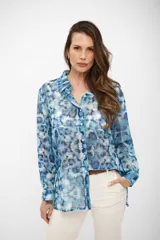 Camisa de manga larga con cuello clásico y cierre frontal de botones, confeccionada en tela liviana con estampado tipo tie-dye en tonos celestes y blancos.