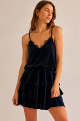 Musculosa de terciopelo color azul marino, con escote en V decorado con puntilla negra, breteles finos regulables y diseño holgado.