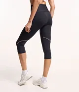 Pantalón corsario deportivo negro, confeccionado en poliamida y elastano, con cintura alta, bolsillos laterales y detalle de línea contrastante en el lateral.
