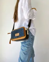 Bandolera rectangular combinada en color negro, beige y blanco, con correa larga regulable y bolsillo exterior con cierre.