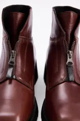 Borcegos de cuero color marrón con cierre frontal y suela track negra.