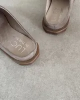 Zueco de cuero vacuno color tostado, con diseño de punta cuadrada y estilo destalonado.