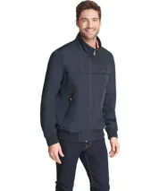 Campera bomber Tommy Hilfiger azul marino con cuello alto, cierre frontal con cremallera, dos bolsillos laterales con cremallera, puños y bajo elásticos. Tiene el logo de Tommy Hilfiger bordado en el pecho y un parche con el logo en la manga izquierda. El interior del cuello tiene detalles en rojo, blanco y azul.