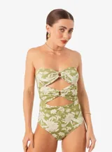 Traje de baño enterizo color verde con estampado floral blanco, corte strapless con aberturas en el abdomen y detalle de nudo en el busto.