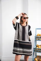 Vestido corto tejido a rayas horizontales en tonos beige y blanco, con cuello redondo y mangas cortas.