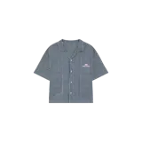 Camisa boxy de manga corta Eme Studios con diseño a rayas finas verticales, cuello solapa, cierre frontal de botones y dos bolsillos delanteros amplios. Incluye detalle de bordado de la marca en el pecho.