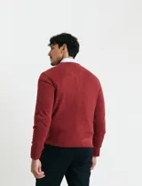 Sweater de punto color ladrillo con cuello en V y mangas largas.
