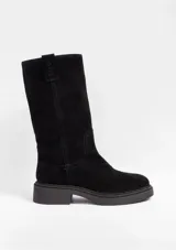 Bota de caña media confeccionada en cuero genuino color negro, con diseño clásico, punta redondeada y suela de goma con taco bajo.