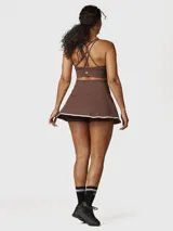 Top deportivo color chocolate con espalda cruzada y logo blanco en el frente. Ofrece sujeción media y está confeccionado con tecnología Aloe Vera para mayor suavidad.